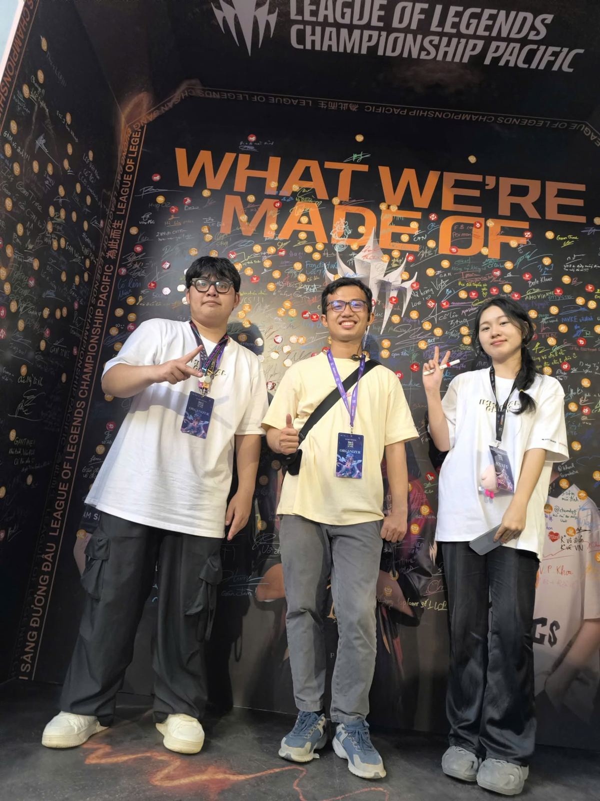 Tom cùng 2 thành viên đội esport LMHT đeo thẻ Organizer trước tường 'What We're Made Of' của LCP